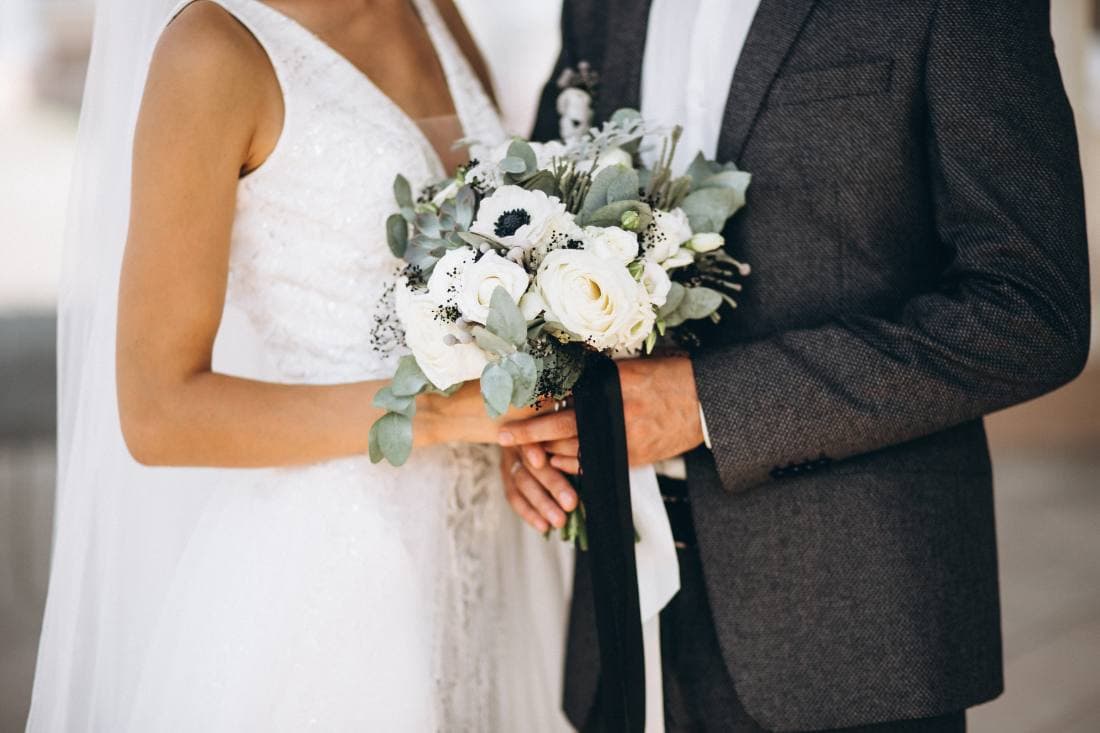A bride and groom holding each other on a path outside the venue